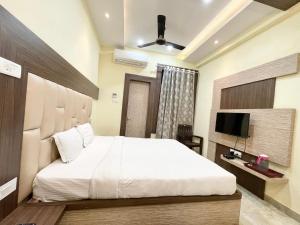 um quarto com uma cama grande e uma televisão em Hotel Nandini Palace ! Varanasi ! ! fully-Air-Conditioned-hotel family-friendly-hotel, near-Kashi-Vishwanath-Temple and Ganga ghat em Varanasi