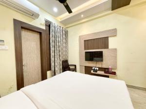 um quarto com uma cama e uma televisão de ecrã plano em Hotel Nandini Palace ! Varanasi ! ! fully-Air-Conditioned-hotel family-friendly-hotel, near-Kashi-Vishwanath-Temple and Ganga ghat em Varanasi