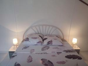 een slaapkamer met een bed met twee lampen erop bij Loue Maison entière in Cilaos
