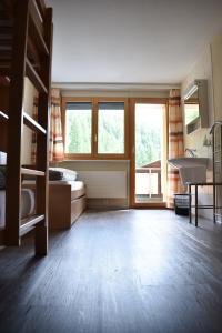 - une chambre avec des lits superposés et une chambre avec une fenêtre dans l'établissement Restaurant & Hostel Hole in One, à Randa