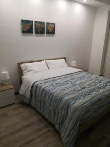 1 cama en un dormitorio con 2 cuadros en la pared en CIVICO 1, en Valguarnera Caropepe