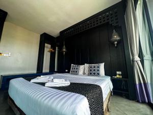 a bedroom with a large bed with towels on it at Srisawara Casa Hotel in Krabi town
