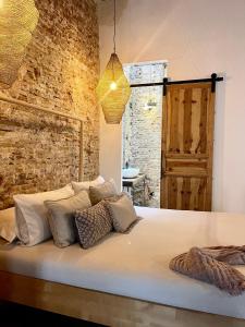 uma cama num quarto com uma parede de tijolos em Casa Poeta Pelayo em Cartagena