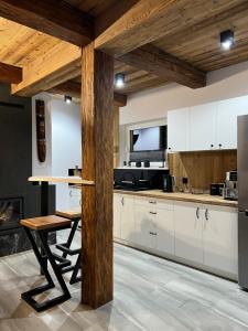 a kitchen with white cabinets and a wooden table at Domek Viking z prywatnym ogrzewanym basenem sauną oraz balią z jacuzzi in Gródek Nad Dunajcem