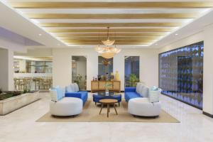 a living room with two chairs and a blue couch at Swiss-Belcourt Lombok in Praya