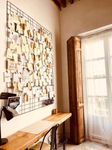 um quarto com uma mesa de madeira e uma parede de copos em Casa Poeta Pelayo em Cartagena
