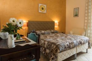 ein Schlafzimmer mit einem Bett und einem Tisch mit Blumen darauf in der Unterkunft Locanda dei Fiori in Pistoia