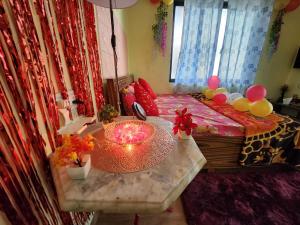 a room with a bed with a table with a candle at Bhumi Holiday Home in Alibaug