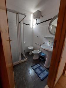bagno con lavandino, servizi igienici e specchio di Porto Cesareo Residenze a Porto Cesareo