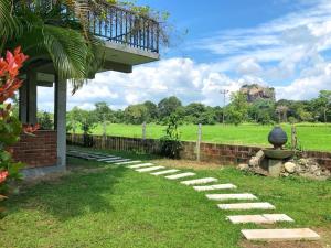 einen Garten mit einem Gehweg, der zu einem Gebäude führt in der Unterkunft Kashyapa Kingdom View Home in Sigiriya