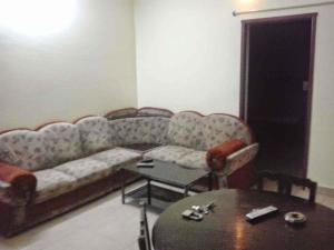 The Briggo Service Aparment في بونديتْشيري: غرفة معيشة مع أريكة وطاولة