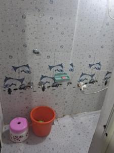un baño con una pared con delfines pintados en ella en Shree Mohan Home stay, en Ujjain
