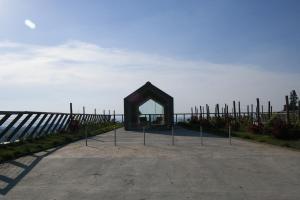 a wooden arch in a parking lot next to a fence at Foresteria Settevie in Treiso