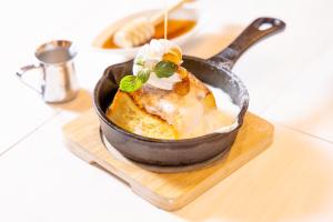 a bowl of food in a pan on a cutting board at KOKO HOTEL Shinjuku Yotsuya in Tokyo