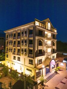 a large white building with a lit up at Westwood Residences in Arusha