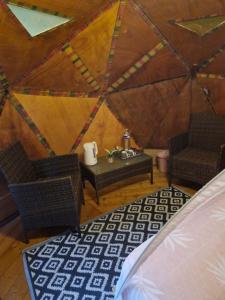 聖克勞德的住宿－Dôme en bord de rivière，蒙古包内的房间,配有两把椅子和一张桌子