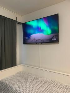 1 dormitorio con TV de pantalla plana en la pared en Yksiö keskustassa saunalla, en Iisalmi