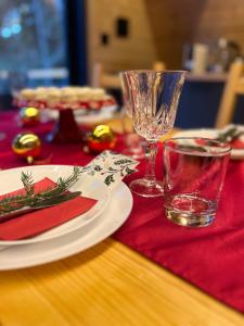un tavolo con due piatti e un bicchiere di vino sopra di Viktorija chalet a Kopaonik