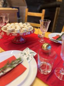 a table with a red table cloth with a plate of cookies at Viktorija chalet in Kopaonik