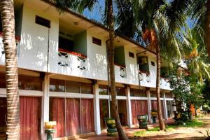 un edificio con palme di fronte ad esso di Hotel Nirmani a Anuradhapura