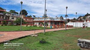 a park with a building in the middle of a city at Varam Homestay in Madikeri