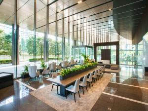 a lobby with a table and chairs and windows at Villa Fontaine Grand Tokyo Tamachi in Tokyo