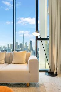 a living room with a white couch and a large window at Upside Living - City Escape - WFH Friendly-Business Bay in Dubai