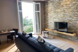 濱海博略的住宿－Appartement Baous 300m de la mer - Happy Rentals，客厅设有蓝色的沙发和砖墙