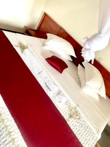 a bed with red and white sheets and pillows at Romantic Getaways in Gitesi