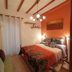 ein Schlafzimmer mit einem Bett mit einer orangefarbenen Wand in der Unterkunft a casa di nonna Elza in La Spezia