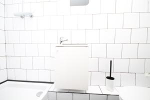 サン・ドニにある06 - Chambre avec TV proche Paris et transports WIFIの白いタイル張りの壁のバスルーム(シンク付)