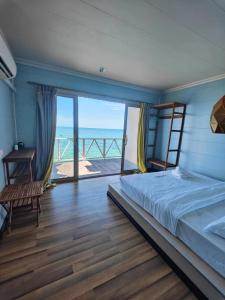 a bedroom with a bed and a view of the ocean at Aloha Mabul Scuba Lodge in Pulau Mabul 