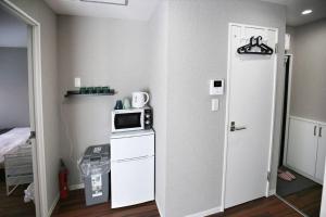 a room with a kitchen with a microwave and a door at Edogawa Japanese Style Apartment 202 has direct access to Akihabara and Shinjuku, with convenient transportation and free WiFi in Tokyo