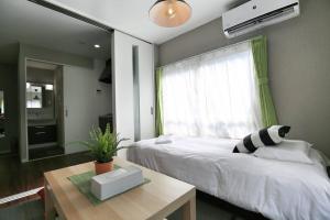 a bedroom with a bed with a window and a table at Edogawa Japanese Style Apartment 202 has direct access to Akihabara and Shinjuku, with convenient transportation and free WiFi in Tokyo