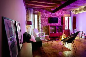 - un salon avec des murs et des chaises violets dans l'établissement Dormsy aparthotel House, à Arenys de Mar