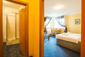 a hotel room with a bed and a bathroom at Hotel Altstadt in Effeld