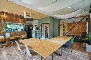 a room with two wooden tables and chairs in it at MtFuji Guest House Kikkake in Fujiyoshida