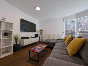 a living room with a couch and a flat screen tv at Forrest-Hugging Townhouse with Private Garden in Zagreb
