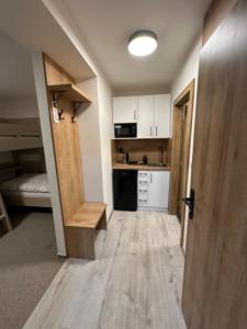 a room with a kitchen with a counter and a door at Apartmány VESNA in Nova Ves nad Nisou