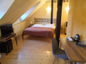 1 dormitorio con 1 cama, TV y mesa en Boutique Hotel Templ en Mikulov