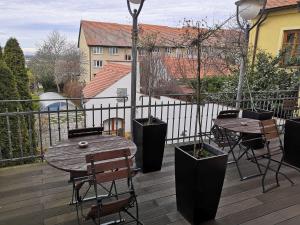 a wooden deck with tables and chairs on a balcony at Boutique Hotel Templ in Mikulov