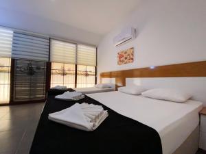オルデニズにあるZehra Hotel - Halal All Inclusiveのベッドルーム1室(ベッド2台、白いシーツ、タオル付)