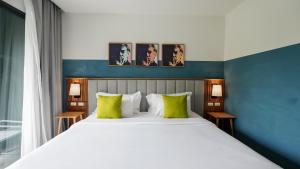 卡伦海滩Sugar Marina Hotel - ART - Karon Beach的卧室里有一张白色的大床，上面放着绿色的枕头