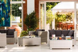un gruppo di sedie e tavoli in vimini su un patio di Hotel Terme Millepini a Montegrotto Terme