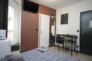 a bedroom with a bed and a table and a television at 09 - Chambre proche Paris et Transports avec TV WIFI in Saint-Denis