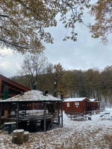 um pavilhão com neve no chão ao lado de um edifício em B&B Snow Village Roccaraso em Roccaraso