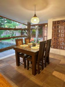a dining room with a wooden table and chairs at Ndalem Rahadi in Kaliurang