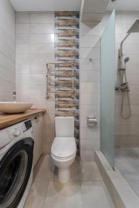 La salle de bains est pourvue de toilettes, d'un lavabo et d'un lave-linge. dans l'établissement Luxury flat near Opera, à Lviv