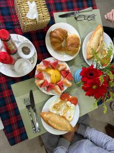una persona sentada en una mesa con platos de desayuno en Simon House Hoi An en Hoi An