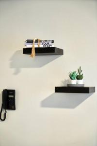 a wall mounted shelf with a phone and plants at Westwood Residences in Arusha